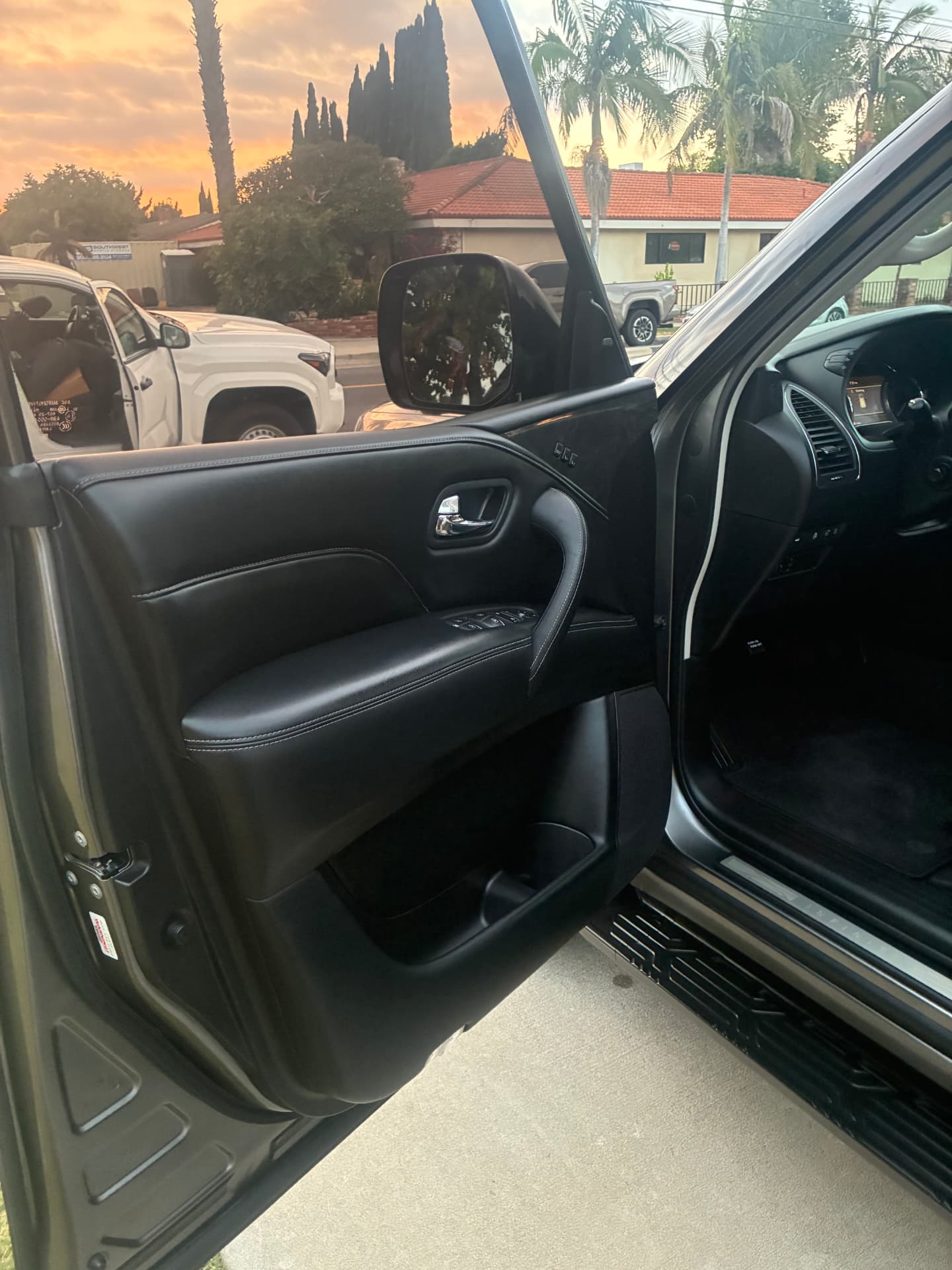 Clean driver door panel with white contrast stitching after an interior detail